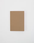 A closed A5 Kraft cover notebook laying flat on a white background. 